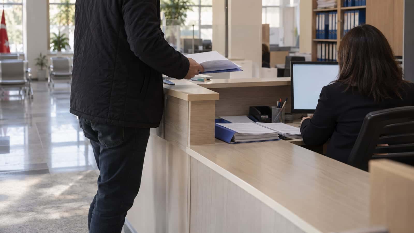 Belediyenin yapı kontrol biriminde iskân belgesi için evraklarını hazırlayan vatandaş