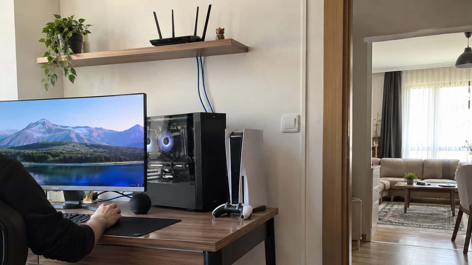 Çalışma masasının üstündeki rafa yerleştirilmiş antenli router ve bilgisayara giden kısa Ethernet kabloları